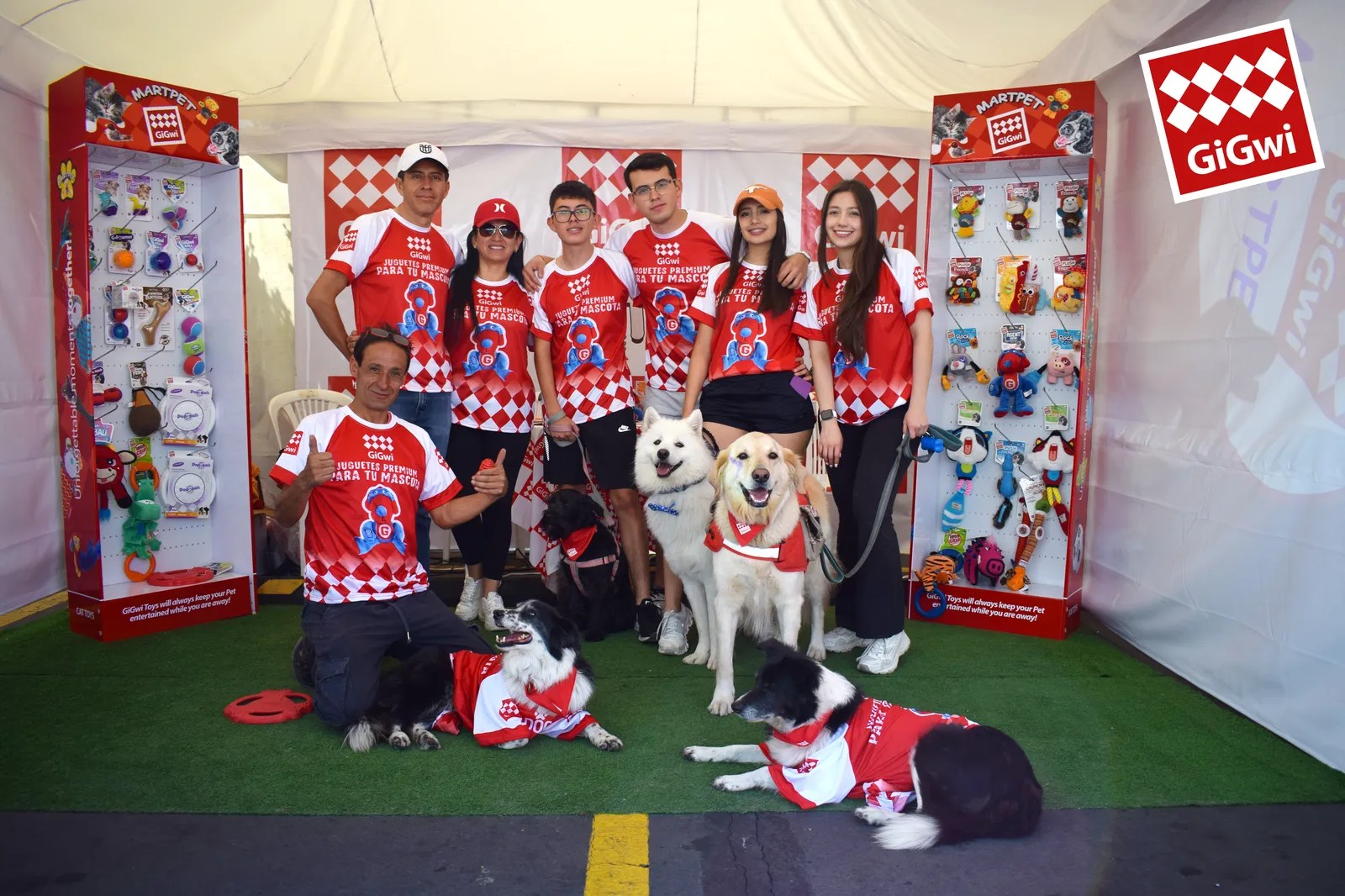 Equipo de MARTPET con sus perros en el stand de GiGwi, con exhibidores de juguetes a los lados